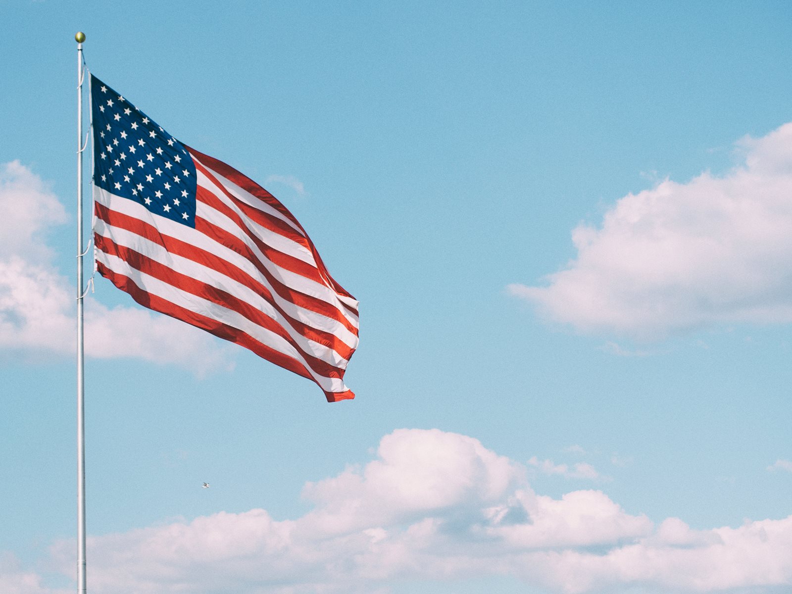 US Flag in cloudy sky