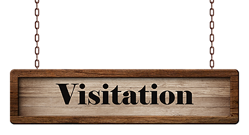 Brown sign hanging from chains with the word visitation.
